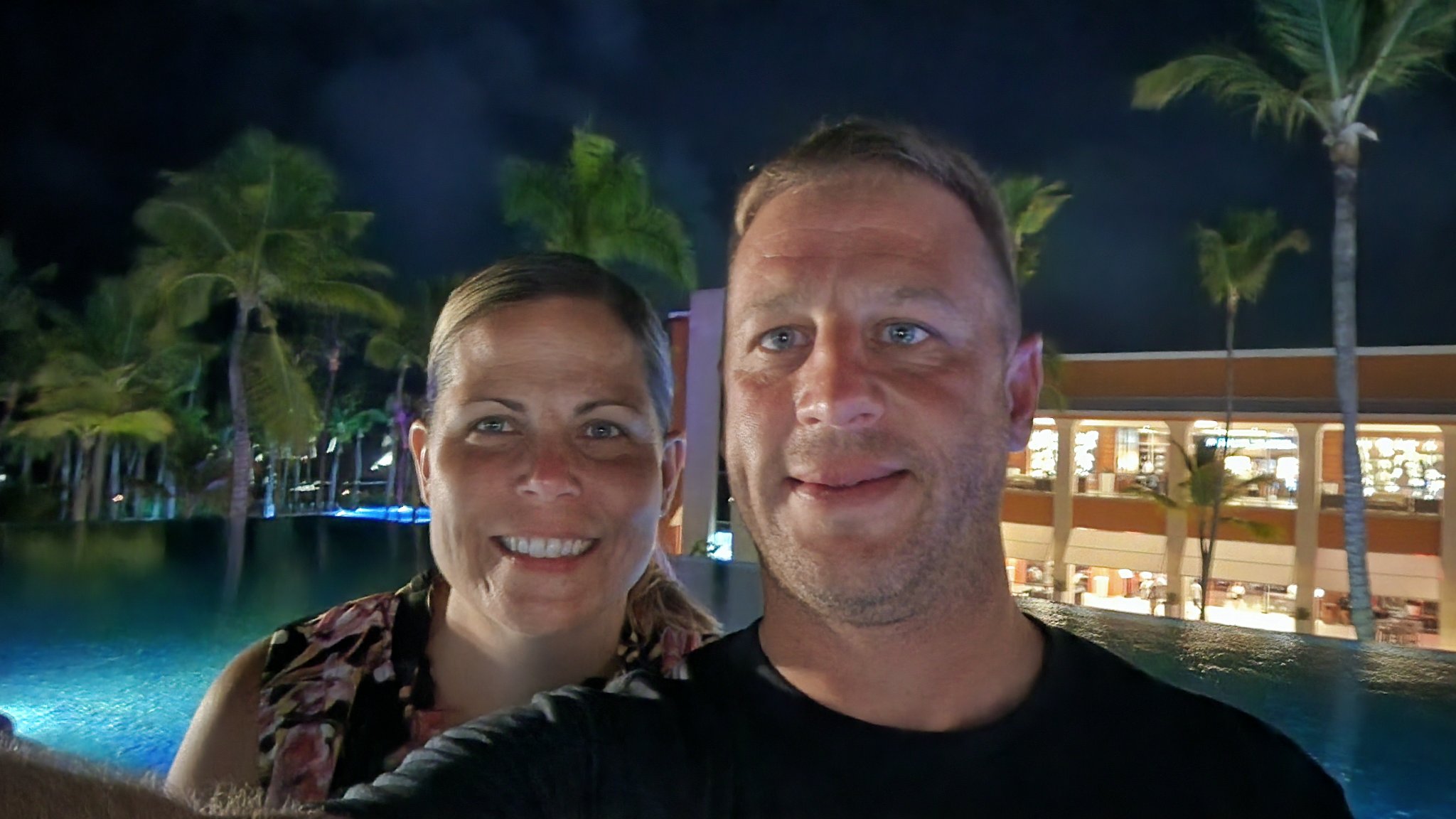 Couple selfie by the glowing resort pool